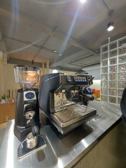 Hình ảnh thực tế của máy xay cà phê Eureka Nadir 65 bên cạnh máy pha cà phê Nuova Simonelli Appia Life 1 Group Vol
